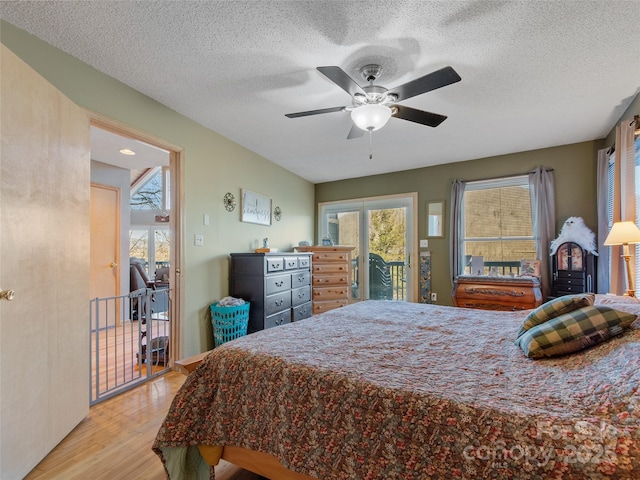 bedroom with access to outside, a textured ceiling, light hardwood / wood-style floors, and ceiling fan