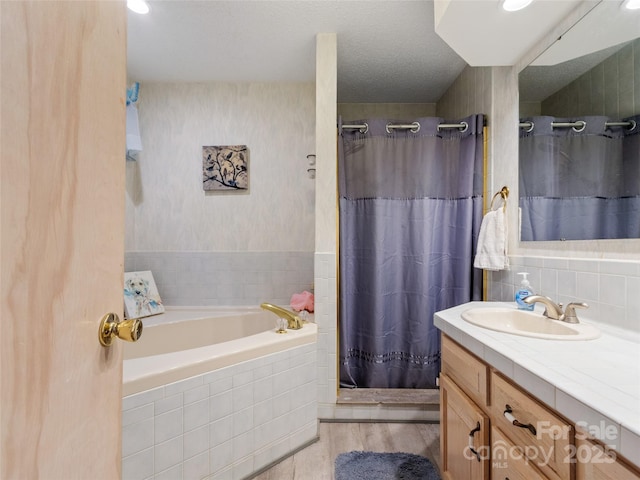 bathroom with separate shower and tub, vanity, wood-type flooring, and a textured ceiling