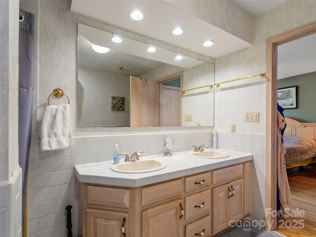 bathroom with vanity, wood-type flooring, and tile walls