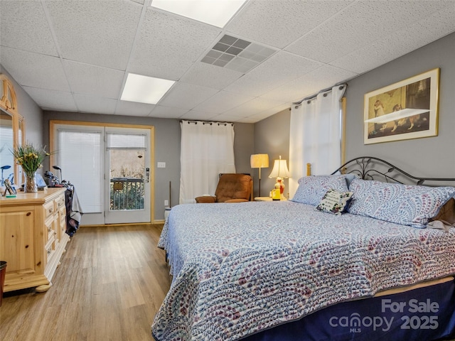 bedroom featuring a paneled ceiling and light hardwood / wood-style floors