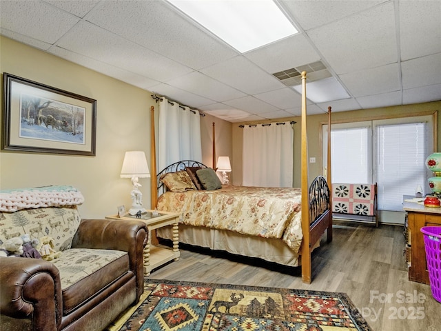 bedroom featuring a paneled ceiling and hardwood / wood-style floors