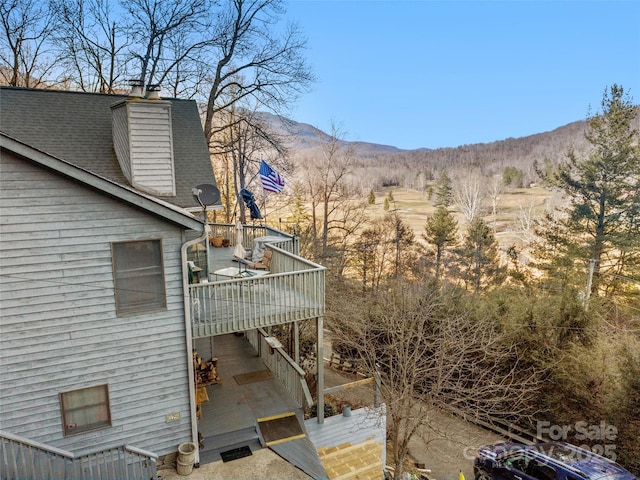 view of home's exterior with a mountain view and a balcony