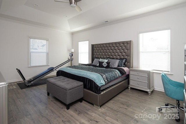 bedroom featuring ceiling fan, dark hardwood / wood-style flooring, and a raised ceiling