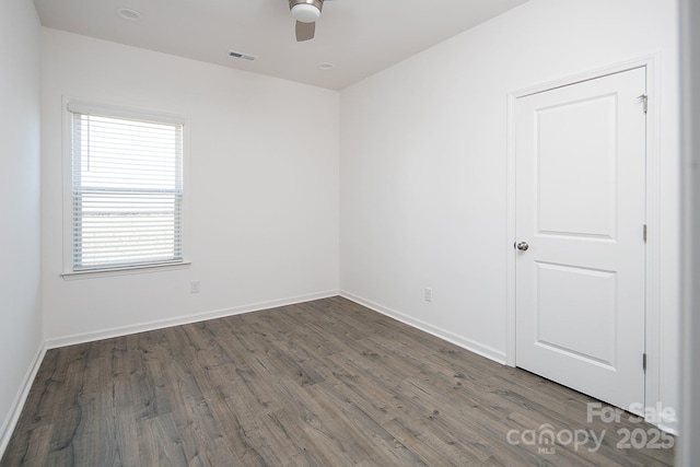 spare room with ceiling fan and dark hardwood / wood-style floors