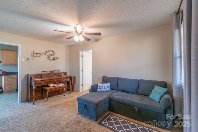 carpeted living room featuring ceiling fan and a textured ceiling