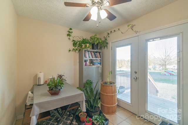 doorway with ceiling fan, french doors, light tile patterned floors, and a textured ceiling