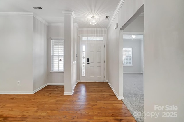 foyer entrance featuring ornamental molding and wood-type flooring