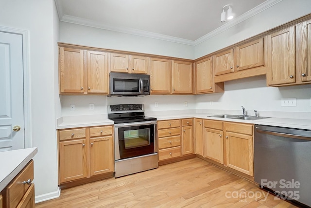 kitchen featuring sink, ornamental molding, stainless steel appliances, and light hardwood / wood-style floors