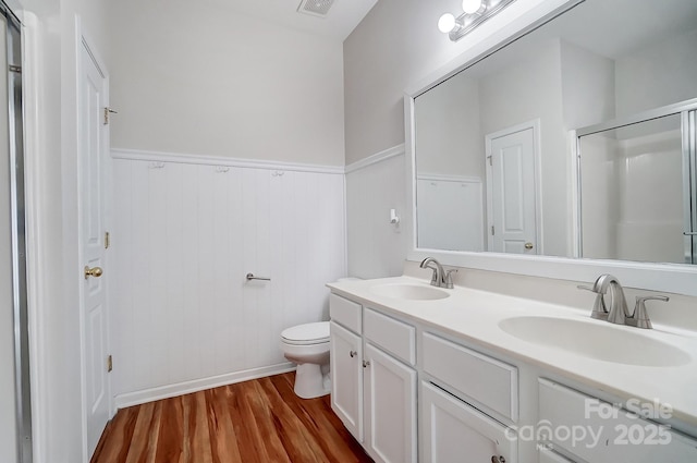 bathroom featuring vanity, hardwood / wood-style floors, a shower with shower door, and toilet