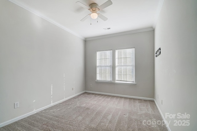 spare room featuring ornamental molding, ceiling fan, and carpet