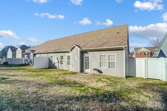 rear view of property featuring a lawn