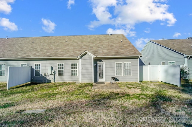 rear view of house featuring a yard