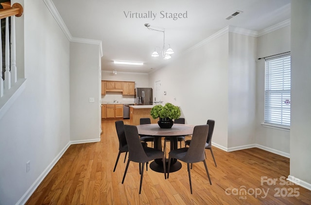 dining room with ornamental molding, a notable chandelier, and light hardwood / wood-style flooring