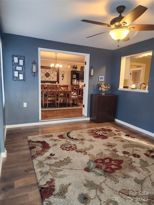 living room featuring ceiling fan with notable chandelier and wood-type flooring