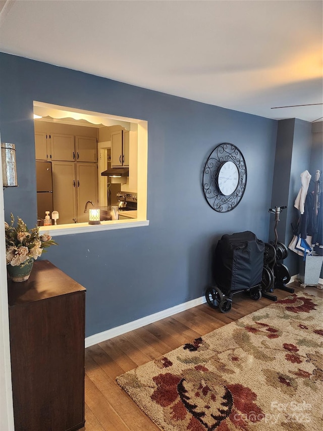 interior space featuring stainless steel fridge and wood-type flooring