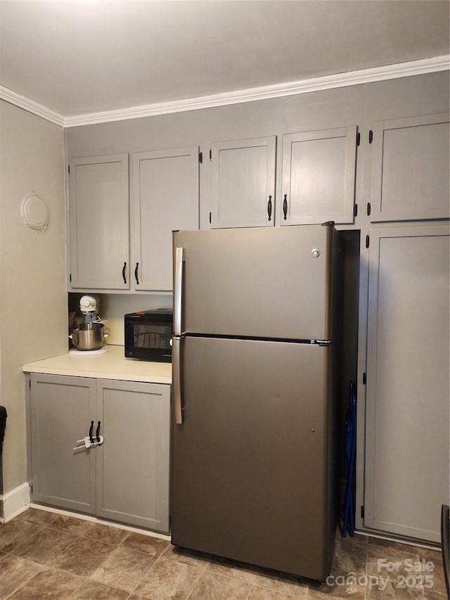 kitchen featuring crown molding and stainless steel refrigerator