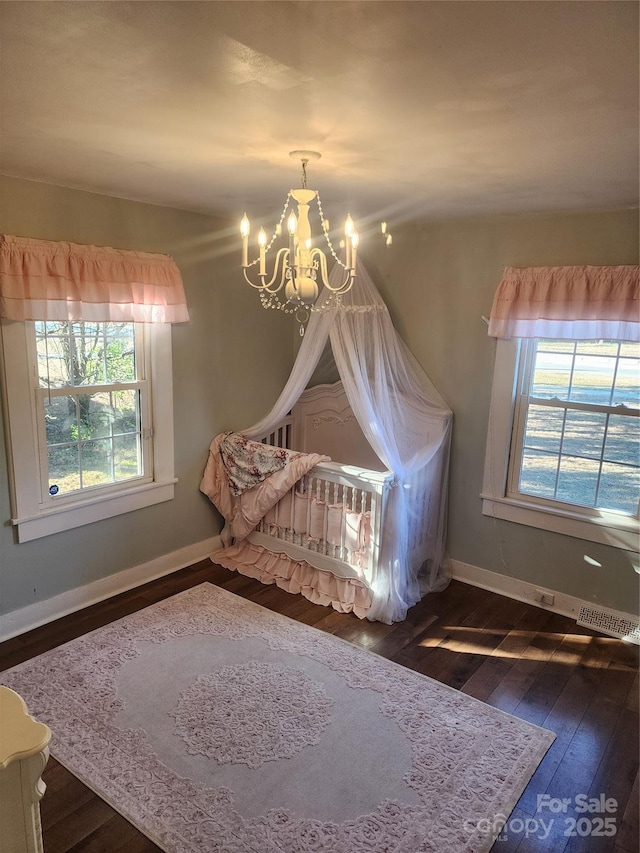 unfurnished bedroom with a chandelier, multiple windows, and dark wood-type flooring