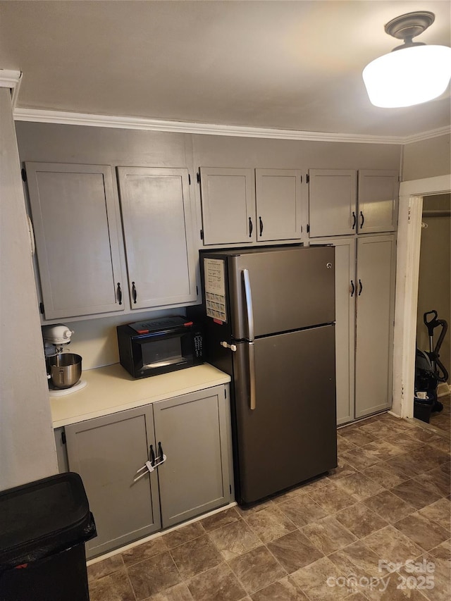 kitchen with stainless steel fridge, crown molding, and gray cabinetry