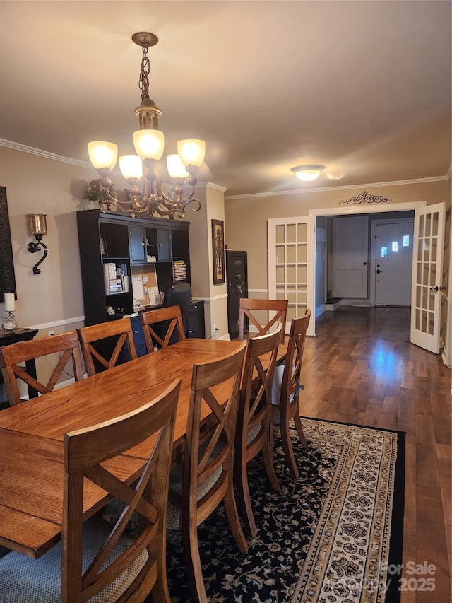 dining area with french doors, ornamental molding, and a notable chandelier