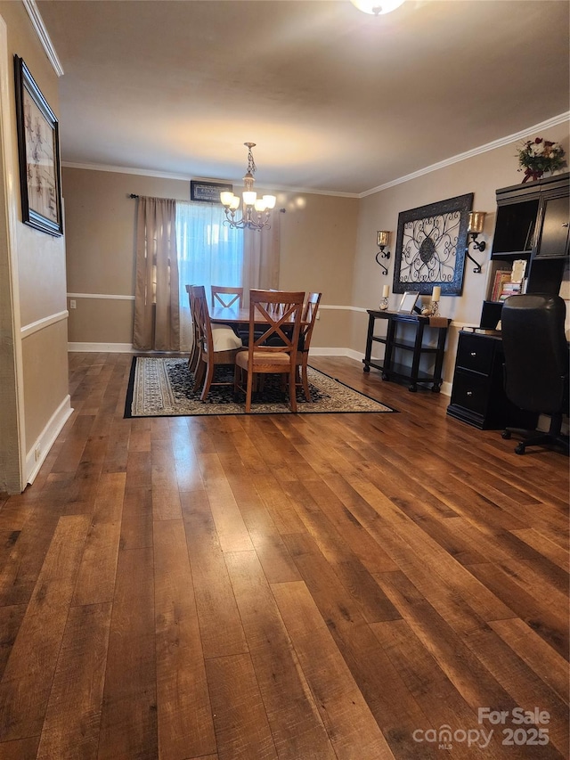 dining room with dark hardwood / wood-style floors, crown molding, and an inviting chandelier