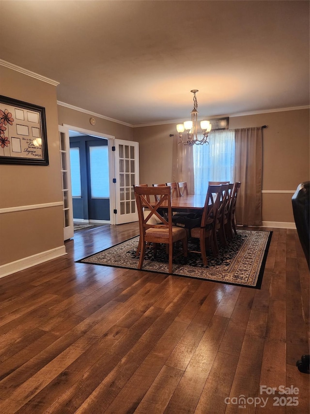 dining area with a notable chandelier, crown molding, and dark wood-type flooring