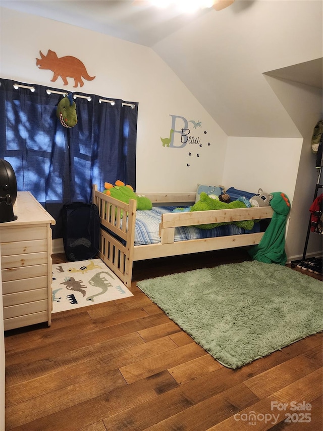 bedroom with lofted ceiling and wood-type flooring