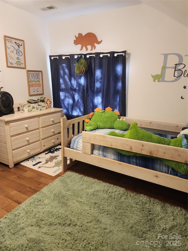 bedroom with hardwood / wood-style floors and vaulted ceiling