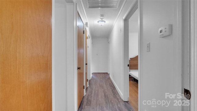 hallway with wood-type flooring and crown molding