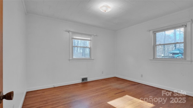 unfurnished room with light wood-type flooring and crown molding