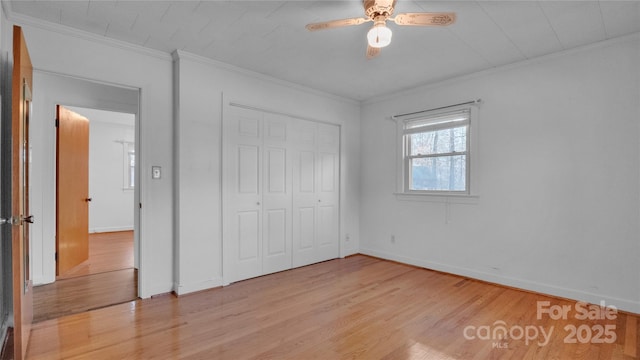 unfurnished bedroom featuring a closet, light hardwood / wood-style flooring, ceiling fan, and ornamental molding