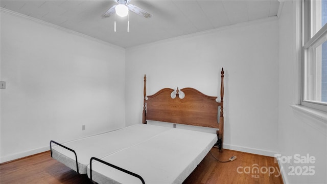 bedroom with wood-type flooring, ceiling fan, and crown molding