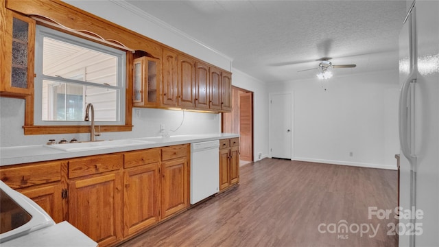 kitchen with white appliances, sink, ceiling fan, light wood-type flooring, and a textured ceiling