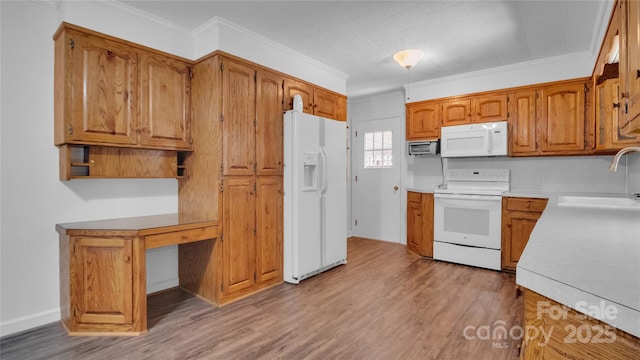 kitchen with light hardwood / wood-style floors, crown molding, white appliances, and sink