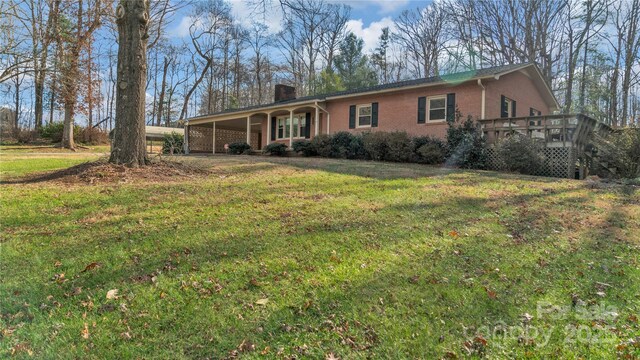 ranch-style home with a deck and a front lawn