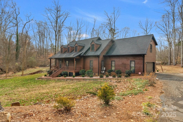 view of front facade with a garage, covered porch, and a front yard