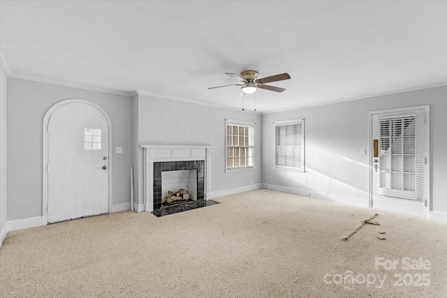 unfurnished living room with light colored carpet, ceiling fan, ornamental molding, and a tiled fireplace