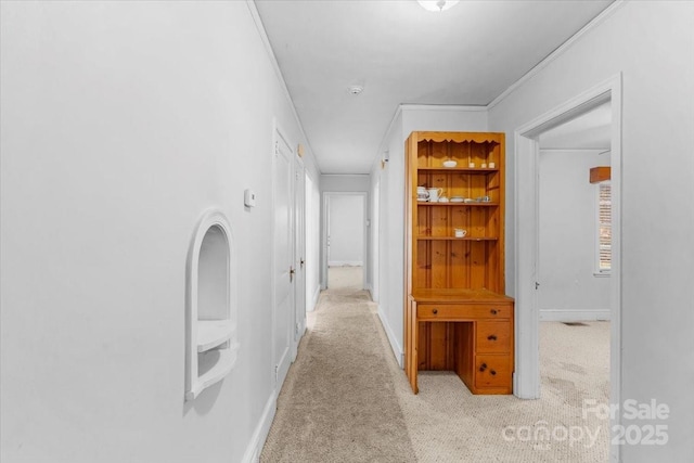 hallway featuring light carpet and crown molding