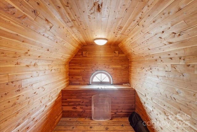 bonus room with wood-type flooring, wooden ceiling, and wood walls