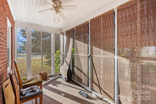 unfurnished sunroom featuring ceiling fan, plenty of natural light, and wooden ceiling