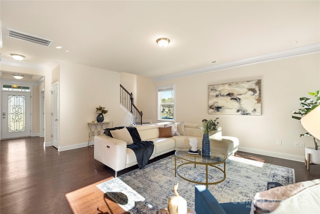 living room with dark hardwood / wood-style floors and crown molding