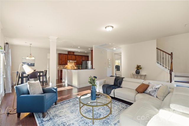 living room with an inviting chandelier and dark hardwood / wood-style flooring