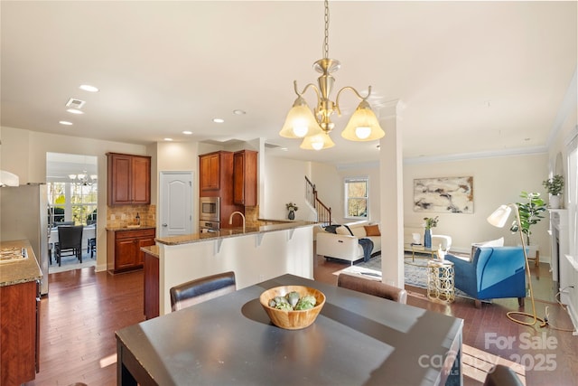 dining space with sink, dark hardwood / wood-style flooring, and an inviting chandelier