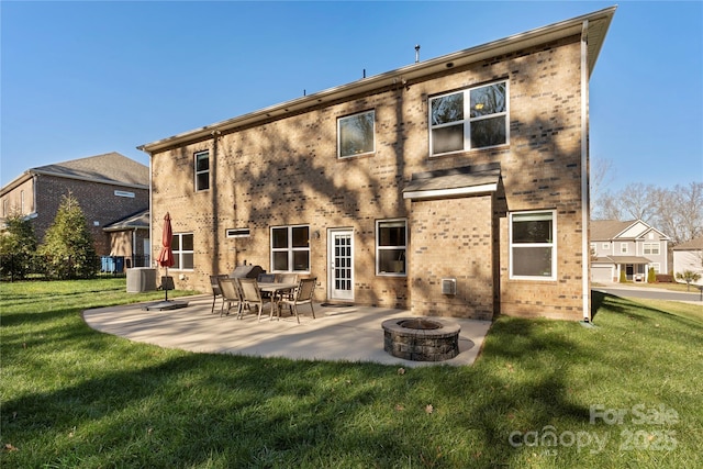 rear view of house featuring a lawn, an outdoor fire pit, central AC unit, and a patio