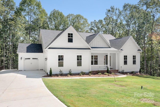 view of front of property featuring a porch, a front yard, and a garage