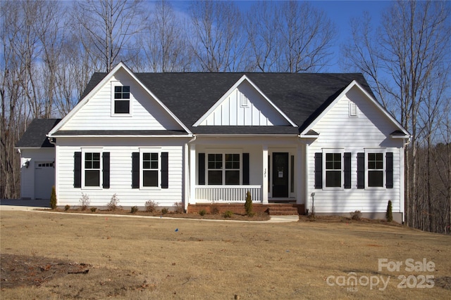 view of front of house featuring a garage, a front lawn, and a porch