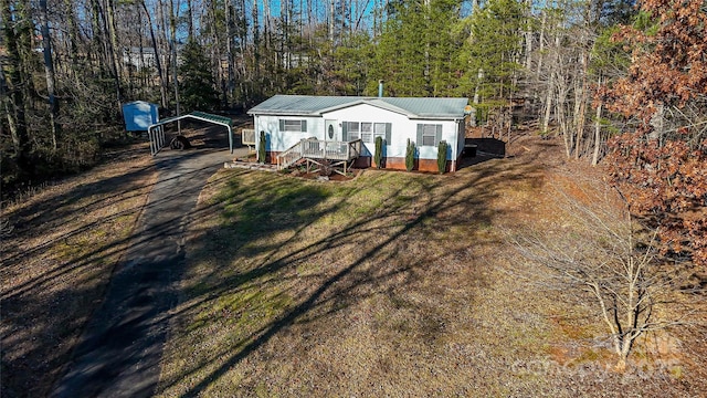 manufactured / mobile home with a front lawn and a carport