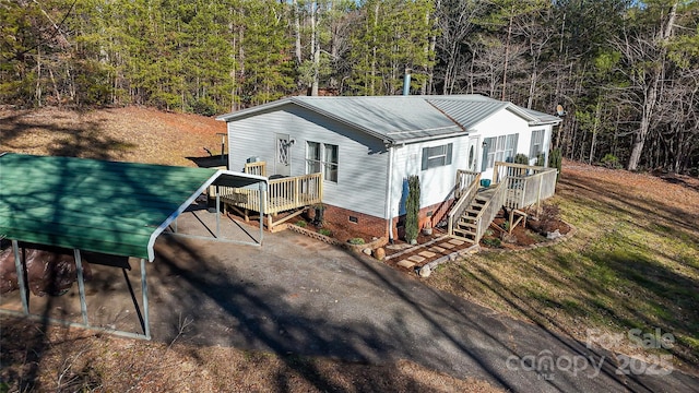 view of front of property with a carport and a wooden deck