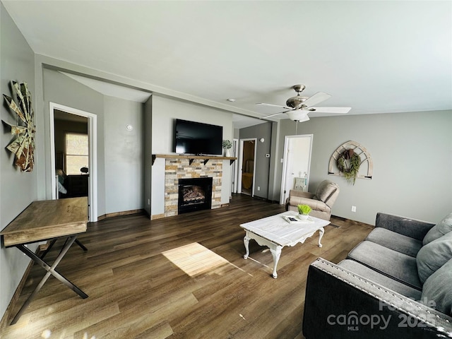 living room featuring ceiling fan, dark hardwood / wood-style flooring, and a fireplace