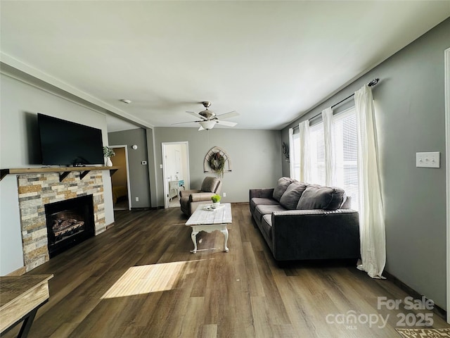 living room with ceiling fan, a fireplace, and dark hardwood / wood-style floors