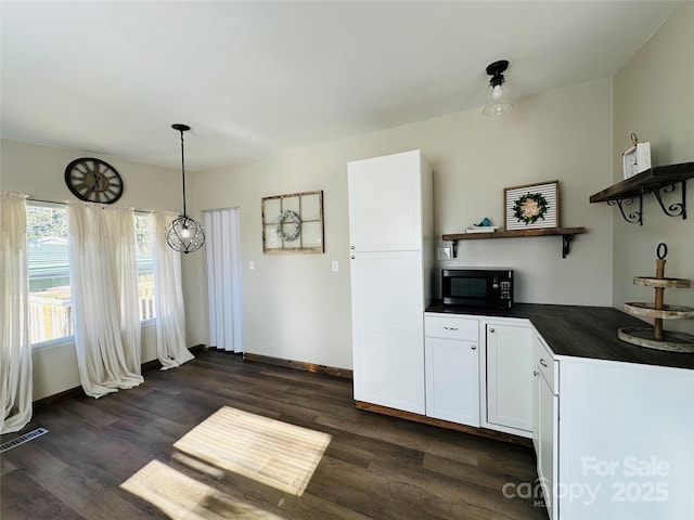 kitchen with dark hardwood / wood-style floors, white cabinetry, and hanging light fixtures